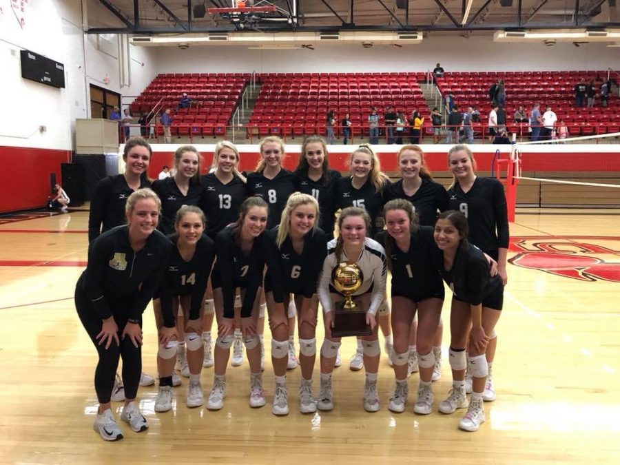 The volleyball team poses with their Bi-District trophy